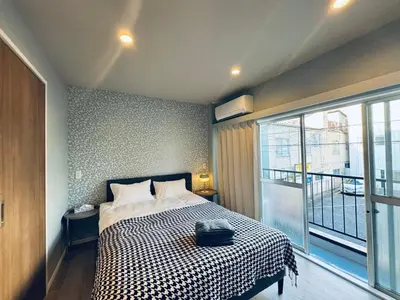 a bedroom with a bed with a black and white checkered blanket at Higashiasakusa House 2-3F-TT0366 in Tokyo