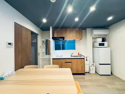 a kitchen with a table and a white refrigerator at Higashiasakusa House 2-3F-TT0366 in Tokyo