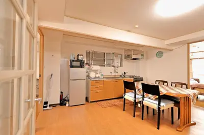 a kitchen with a table and chairs and a refrigerator at \u30b5\u30f3\u30e9\u30a4\u30d5\u677e\u304c\u8c37 in Tokyo
