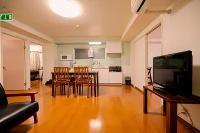 a living room with a table and chairs and a kitchen at \u30b5\u30f3\u30e9\u30a4\u30d5\u677e\u304c\u8c37 in Tokyo