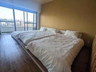 a large white bed in a room with a large window at Quiet residential room 408 walking distance of Shinjuku in Tokyo