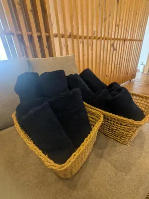 a basket filled with black towels on a couch at Quiet residential room 408 walking distance of Shinjuku in Tokyo