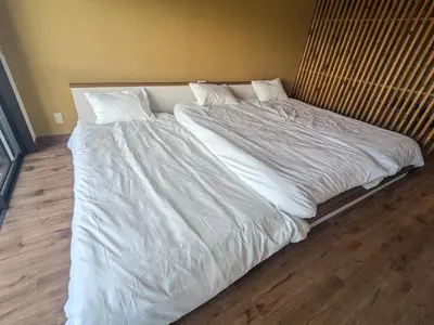 a large bed with white sheets and pillows at Quiet residential room 408 walking distance of Shinjuku in Tokyo