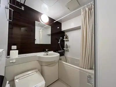 a bathroom with a sink and a toilet and a mirror at Comforting room 410 walking distance of Shinjuku in Tokyo