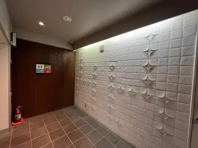 a hallway with a white tile wall and a door at Comforting room 410 walking distance of Shinjuku in Tokyo