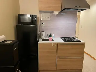 a kitchen with a black refrigerator and a stove at Comforting room 410 walking distance of Shinjuku in Tokyo