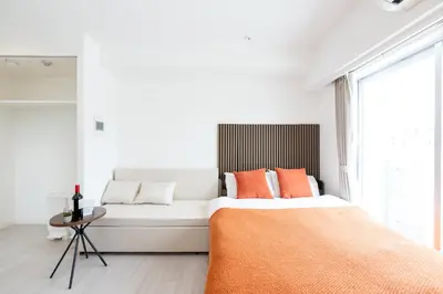 a white bedroom with a bed and a couch at LIVCITY Kinshicho 1201 Skytree view in Tokyo