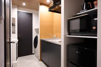 a small kitchen with a microwave and a sink at Blossom House Shibuya in Tokyo