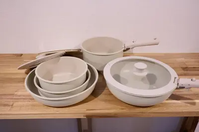 three white bowls and plates on a wooden shelf at Blossom House Shibuya in Tokyo