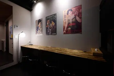 a room with pictures on a wall with a wooden counter at Blossom House Shibuya in Tokyo