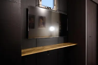 a television on a wall with a wooden shelf at Blossom House Shibuya in Tokyo