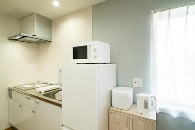 a kitchen with a white refrigerator and a microwave at 107, Takasago A,,Entire house for rent \u9ad8\u7802A in Tokyo