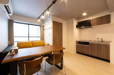 a kitchen and dining room with a wooden table and chairs at SLEEPLAB THE STAY Casual \u6c60\u888b -Ikebukuro- in Tokyo