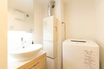 a bathroom with a sink and a washing machine at SLEEPLAB THE STAY Casual \u6c60\u888b -Ikebukuro- in Tokyo