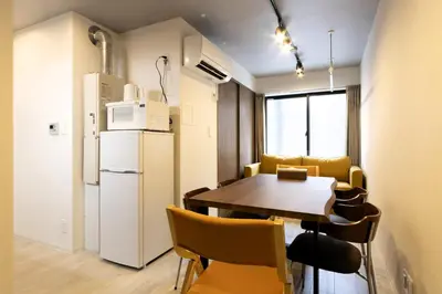 a kitchen and dining room with a table and a refrigerator at SLEEPLAB THE STAY Casual \u6c60\u888b -Ikebukuro- in Tokyo