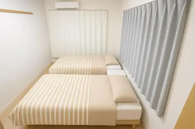 a small room with two beds and a window at \u62bc\u4e0a hotel \u53cc\u5e8a\u623f -SM0389 in Tokyo