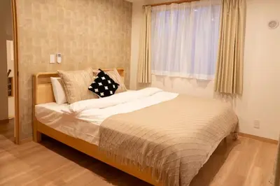 a large bed in a bedroom with a window at \u96f2\u820e\u65c5\u9928 in Tokyo