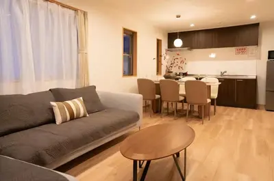 a living room with a couch and a table and a kitchen at \u96f2\u820e\u65c5\u9928 in Tokyo