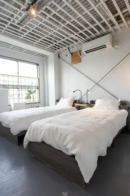 two beds in a large room with white sheets at CREA BASE -Indoor Glamping Retreat- in Tokyo