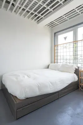 a bed in a white room with a large window at CREA BASE -Indoor Glamping Retreat- in Tokyo