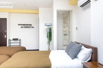 a bedroom with two beds and a table at \u5bcc\u4e45\u30b9\u30af\u30a8\u30a2 in Tokyo