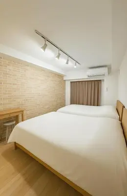 a bedroom with two beds and a desk at \u9526\u7cfb\u753a hotel -SM0380 in Tokyo