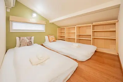 two beds in a small room with shelves at Mori Hotel \u9280\u5ea7 in Tokyo