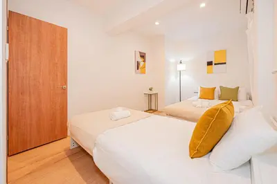 a bedroom with two beds and a wooden door at Mori Hotel \u9280\u5ea7 in Tokyo