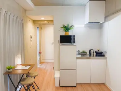 a kitchen with white cabinets and a table and a microwave at \u6d45\u8349 ideas hotel \u5927\u5e8a\u623f-TT0390 in Tokyo