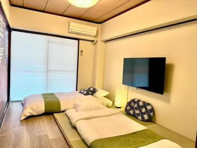 a bedroom with two beds and a flat screen tv at #202 Tokyo Ryogoku Hokusai Katsushika in Tokyo