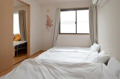 a white bed in a room with a window at \u30e1\u30be\u30f3\u67cf\u6728 in Tokyo