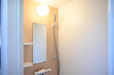 a bathroom with a mirror and a light on the wall at Asakusa Ginza direct access to the airport in Tokyo