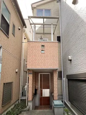 a brick house with a door and a balcony at 2ppl Share House Twin Room with 2 single beds in Tokyo