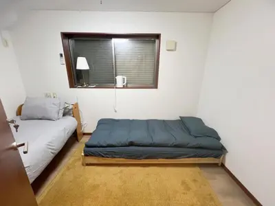 a small bedroom with a bed and a window at 2ppl Share House Twin Room with 2 single beds in Tokyo