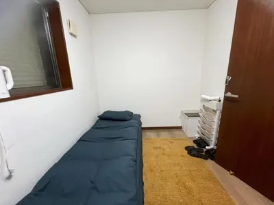 a room with a bed in the corner of a room at 2ppl Share House Twin Room with 2 single beds in Tokyo