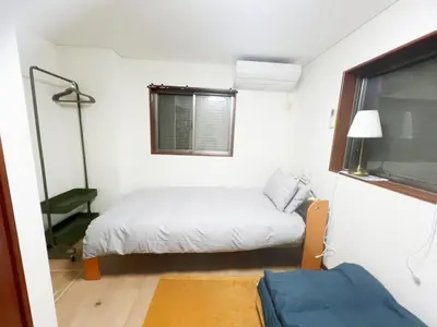 a small bedroom with a bed and a window at 2ppl Share House Twin Room with 2 single beds in Tokyo