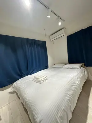 a bed with two white towels on top of it at \u65b0\u7bc9OPEN GREW OJI residence101 in Tokyo