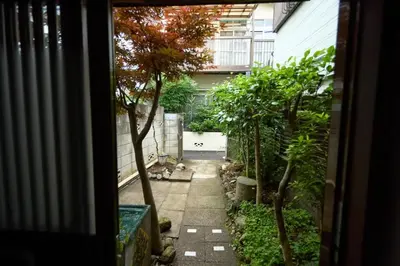 an outside view of a garden with trees and a walkway at Historic House in Sangenjaya - Central Tokyo Stay in Tokyo