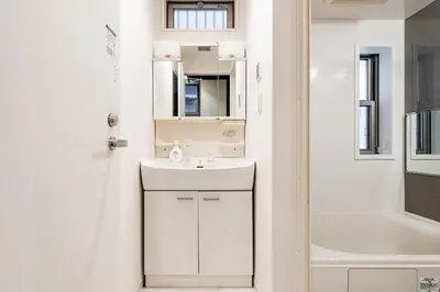 a bathroom with a white sink and a tub at KIX HOTEL Shinjuku west in Tokyo
