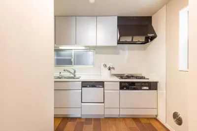 a kitchen with white cabinets and a sink at KIX HOTEL Shinjuku west in Tokyo