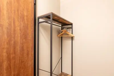 a closet with a wooden door and a hanger at KIX HOTEL Shinjuku west in Tokyo