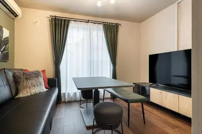 a living room with a couch and a table and a television at KIX HOTEL Shinjuku west in Tokyo