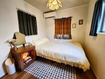 a small bedroom with a bed and a chandelier at Iriya House \u4e0a\u91ce \u6d45\u8349\u3059\u3050\u306e\u4e00\u8ed2\u5bb6\u8cb8\u5207\u30b9\u30c6\u30a4 in Tokyo