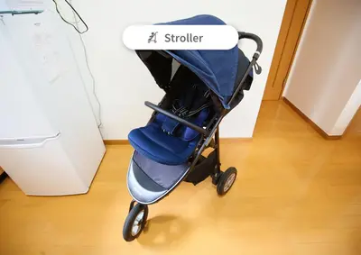 a blue stroller with a sign that says stalker at \u6771\u4eac\u90fd\u845b\u98fe\u533a\u306e\u8cb8\u5207\u4e00\u8ed2\u5bb6 in Tokyo