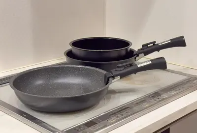 two pans sitting on top of a stove at Good Space Hotel Oshiage in Tokyo