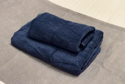 a blue towel sitting on top of a bed at Good Space Hotel Oshiage in Tokyo