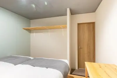 a bedroom with a bed and a wooden table at Good Space Hotel Oshiage in Tokyo