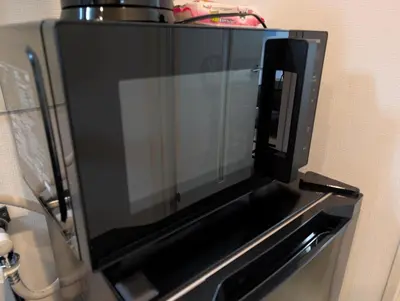 a black microwave oven hanging on a wall at MerisuKabukicho,Tokyo in Tokyo