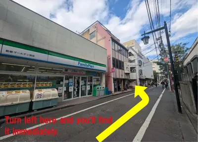 a city street with a yellow arrow pointing to a store at MerisuKabukicho,Tokyo in Tokyo