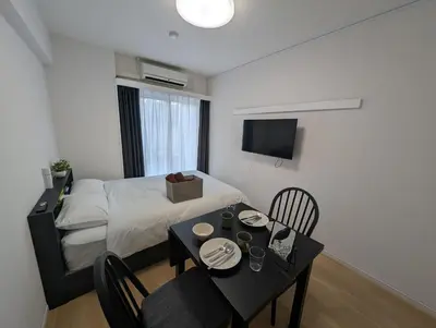 a small room with a bed and a table and chairs at MerisuKabukicho,Tokyo in Tokyo